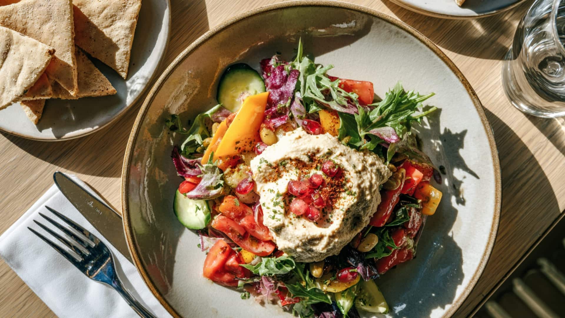 Mediterranean-Salad-With-Hummus-And-Pita-On-Dining-Table (1)